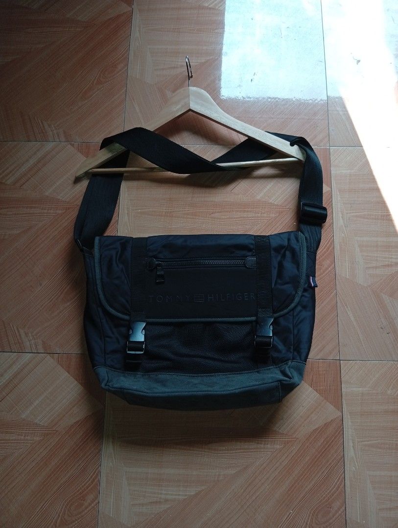 Authentic Tommy Hilfiger Messenger Bag - Black (Water-Resistant) (Category: Sling Bags) located in Buhi. Submitted by thriftmehard (Listing ID 1433072963, Image 1). Description: Dual buckle strap closure para sa extra security. Front zippered pocket sa flap para sa mga gamit na kailangang madaling makuha (tulad ng barya o susi). Adjustable shoulder strap. Malaking main compartment na madalas ay kasya ang notebook o maliit na laptop. Issues: sign 
