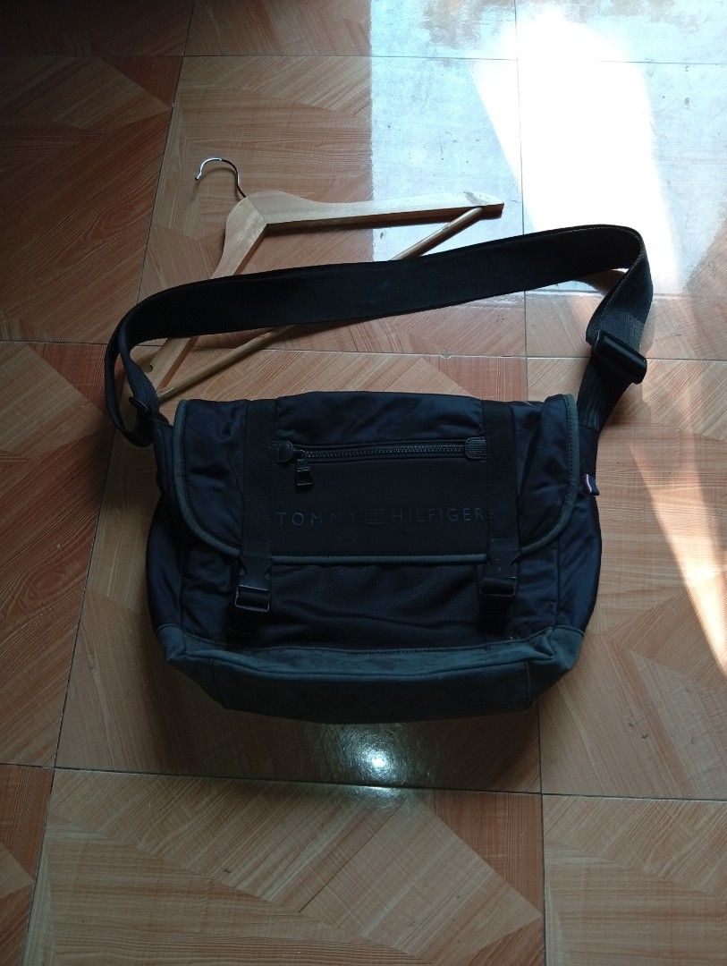 Authentic Tommy Hilfiger Messenger Bag - Black (Water-Resistant) (Category: Sling Bags) located in Buhi. Submitted by thriftmehard (Listing ID 1433072963, Image 2). Description: Dual buckle strap closure para sa extra security. Front zippered pocket sa flap para sa mga gamit na kailangang madaling makuha (tulad ng barya o susi). Adjustable shoulder strap. Malaking main compartment na madalas ay kasya ang notebook o maliit na laptop. Issues: sign 