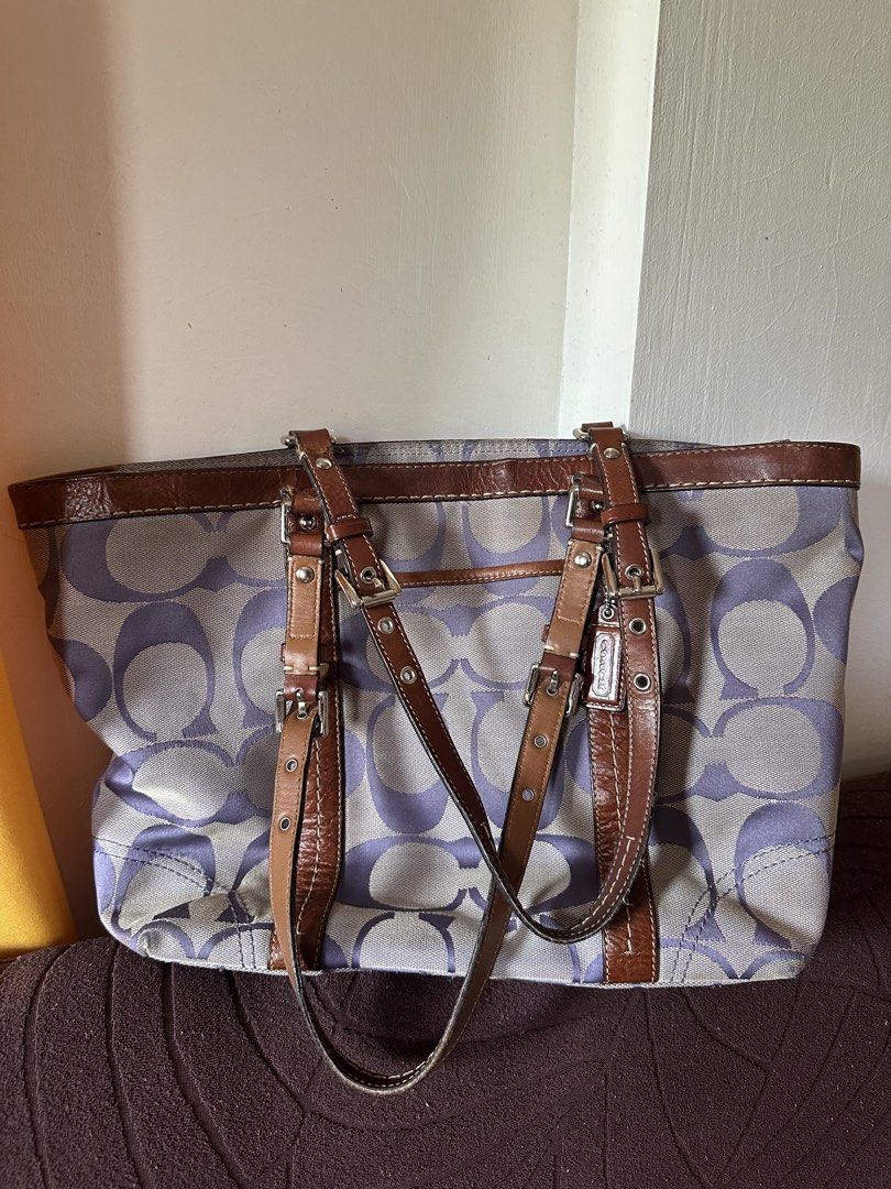 Coach Signature Tote Bag (Category: Luxury Bags & Wallets) located in Badoc. Submitted by ninugh_ (Listing ID 1433034353, Image 2). Description: - Coach tote bag - Signature pattern - Color scheme: Purple and gray with brown leather accents - Brown leather straps and trim - Classic tote design with adjustable straps - Small front pocket - Includes Coach hangtag - Spacious interior - NO ISSUE -need wash lang.