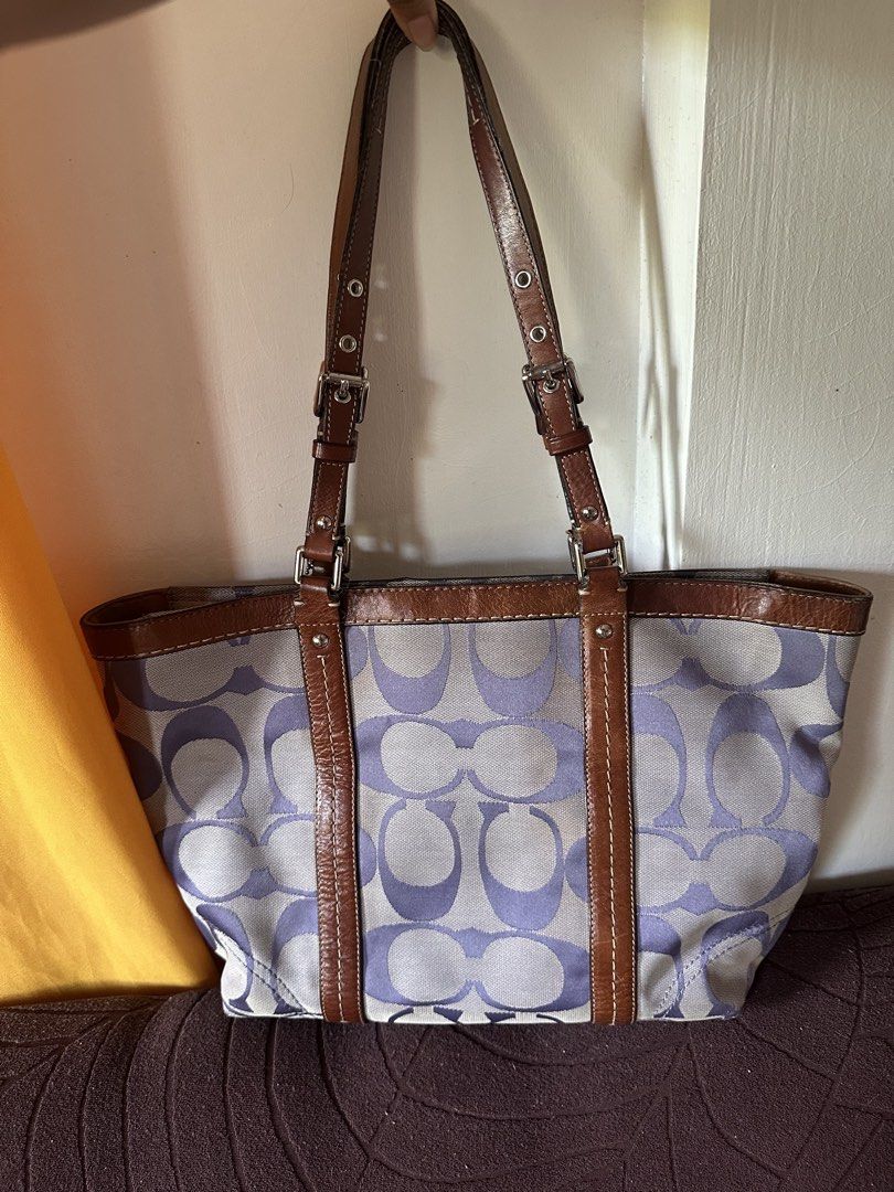 Coach Signature Tote Bag (Category: Luxury Bags & Wallets) located in Badoc. Submitted by ninugh_ (Listing ID 1433034353, Image 3). Description: - Coach tote bag - Signature pattern - Color scheme: Purple and gray with brown leather accents - Brown leather straps and trim - Classic tote design with adjustable straps - Small front pocket - Includes Coach hangtag - Spacious interior - NO ISSUE -need wash lang.