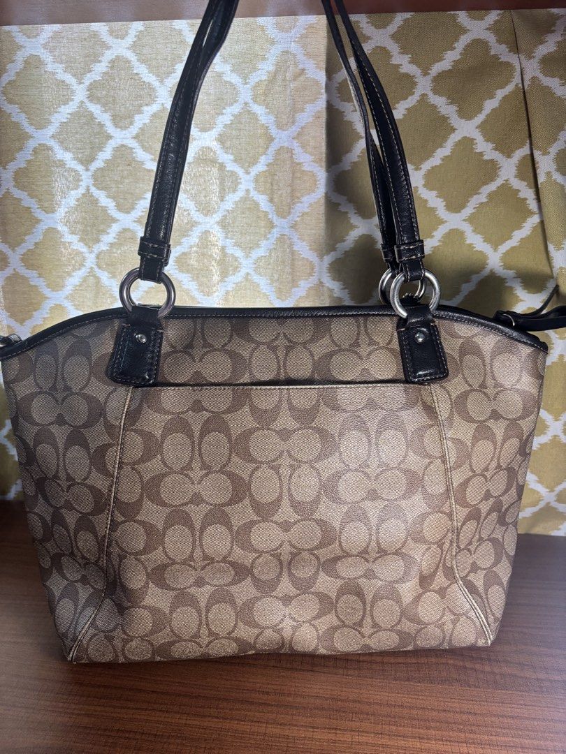Coach Signature Tote Bag (Category: Luxury Bags & Wallets) located in Manila. Submitted by nigel_ky (Listing ID 1433075068, Image 2). Description: - Coach signature tote bag - Black leather handles and trim - Features a front pocket - Spacious interior with multiple compartments - Classic Coach logo on the front - Brown fabric lining - Includes Coach hangtag loc : malate, manila mop : gcash mod : lalamove (sf paid by buyer) + manage expectations!