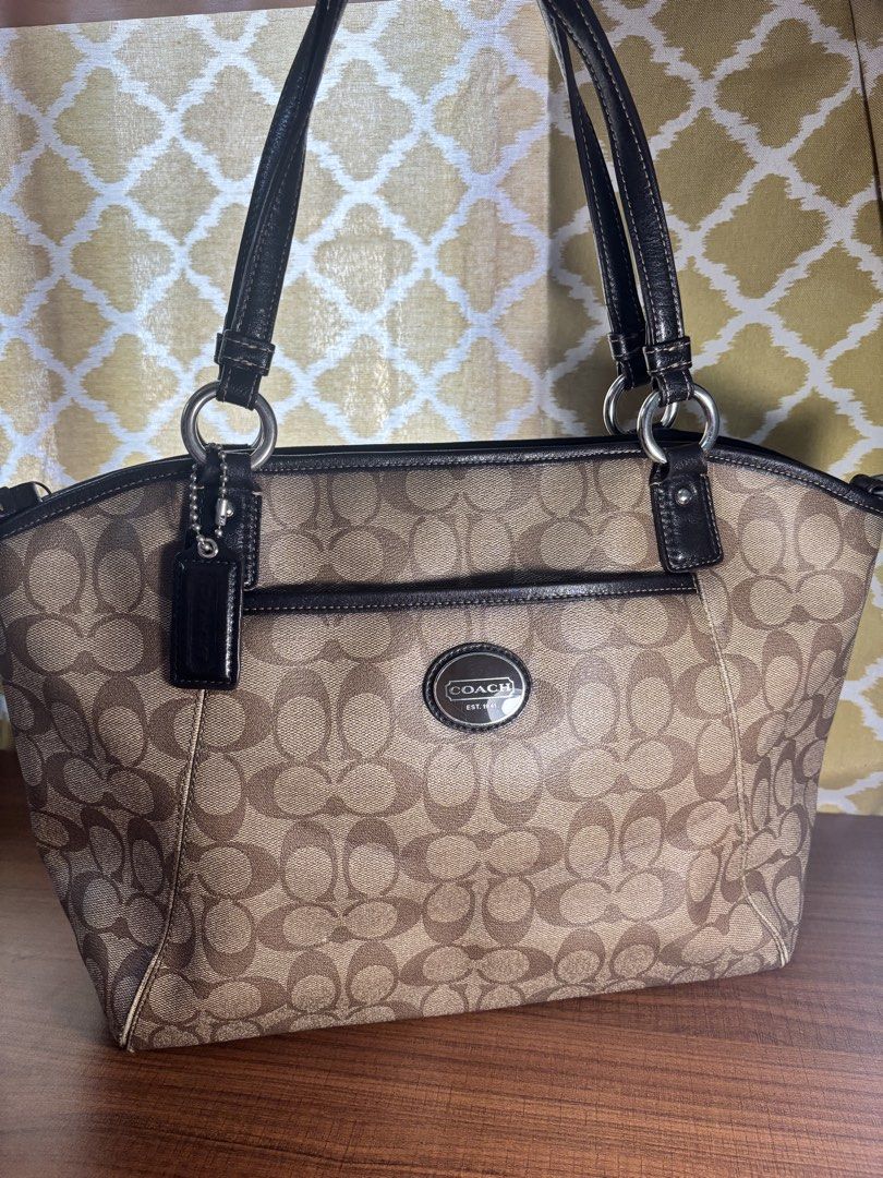 Coach Signature Tote Bag (Category: Luxury Bags & Wallets) located in Manila. Submitted by nigel_ky (Listing ID 1433075068, Image 1). Description: - Coach signature tote bag - Black leather handles and trim - Features a front pocket - Spacious interior with multiple compartments - Classic Coach logo on the front - Brown fabric lining - Includes Coach hangtag loc : malate, manila mop : gcash mod : lalamove (sf paid by buyer) + manage expectations!