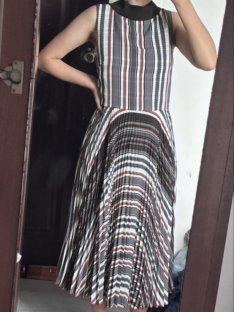 Formal Striped Pleated Dress (Category: Dresses) located in Caloocan City. Submitted by tiannnaaa (Listing ID 1433096771, Image 3). Description: - Sleeveless design - High neckline - Striped pattern (gray, white, red) - Pleated skirt - Midi length - Suitable for various occasions.