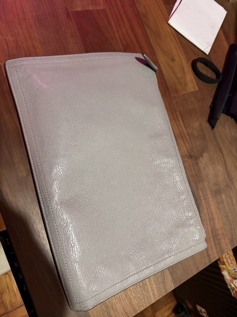 Givenchy Leather Clutch (Category: Luxury Bags & Wallets) located in Manila. Submitted by shoplavma39926 (Listing ID 1433152206, Image 3). Description: - Givenchy clutch - Light grey color - Zipper closure - Givenchy logo on front - Dark fabric interior lining - Rectangular shape - Made of leather.
