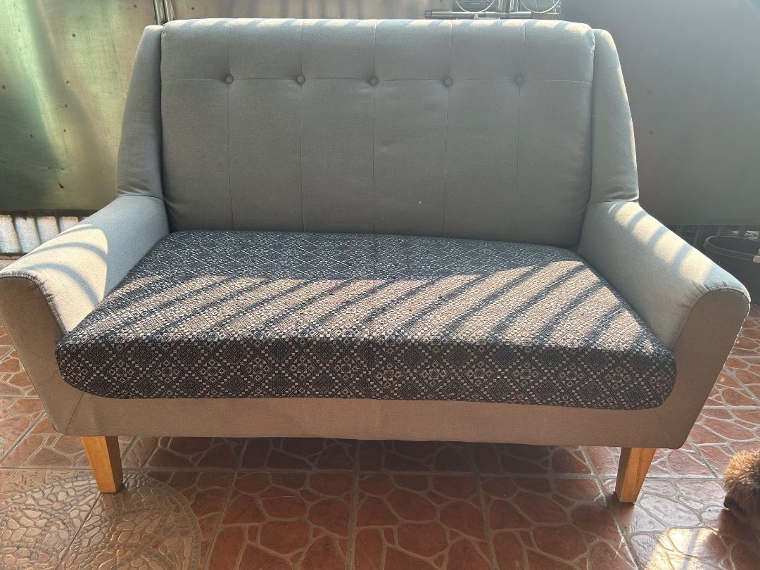 Gray Fabric Loveseat (Category: Sofas) located in Pasig City. Submitted by mina_mahal (Listing ID 1433000818, Image 2). Description: - Stylish loveseat - Gray fabric back and sides - Patterned seat cushion - Wooden legs - Button-tufted backrest and armrests - Comfortable seating option.