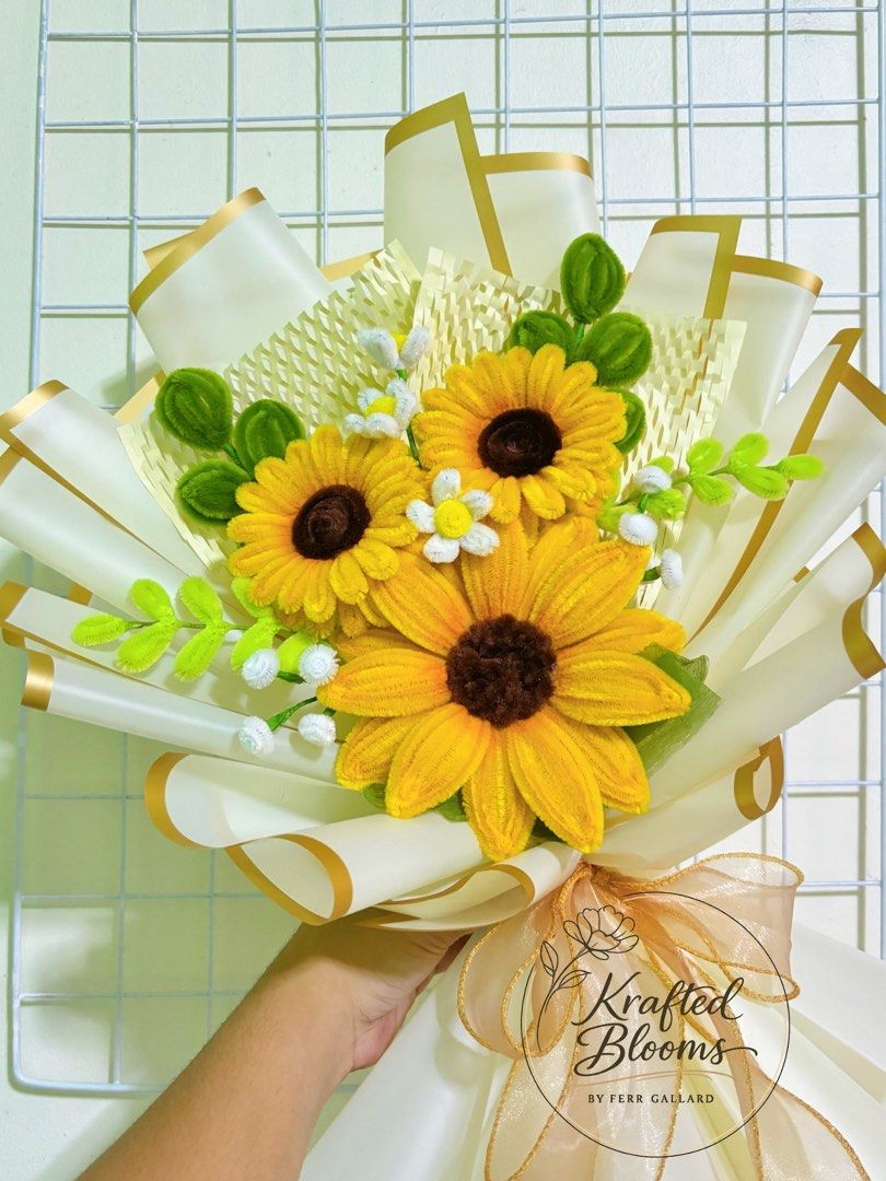 Handmade Sunflower Bouquet Fuzzy Wire (Category: Flowers & Bouquets) located in Taguig. Submitted by ferrgallardsegunda (Listing ID 1433166350, Image 2). Description: - Handmade sunflower bouquet - Features three large sunflowers - Includes smaller white flowers and green leaves - Wrapped in elegant white and gold paper - Tied with a matching ribbon - Perfect for gifting or decor - Crafted by Krafted Blooms.