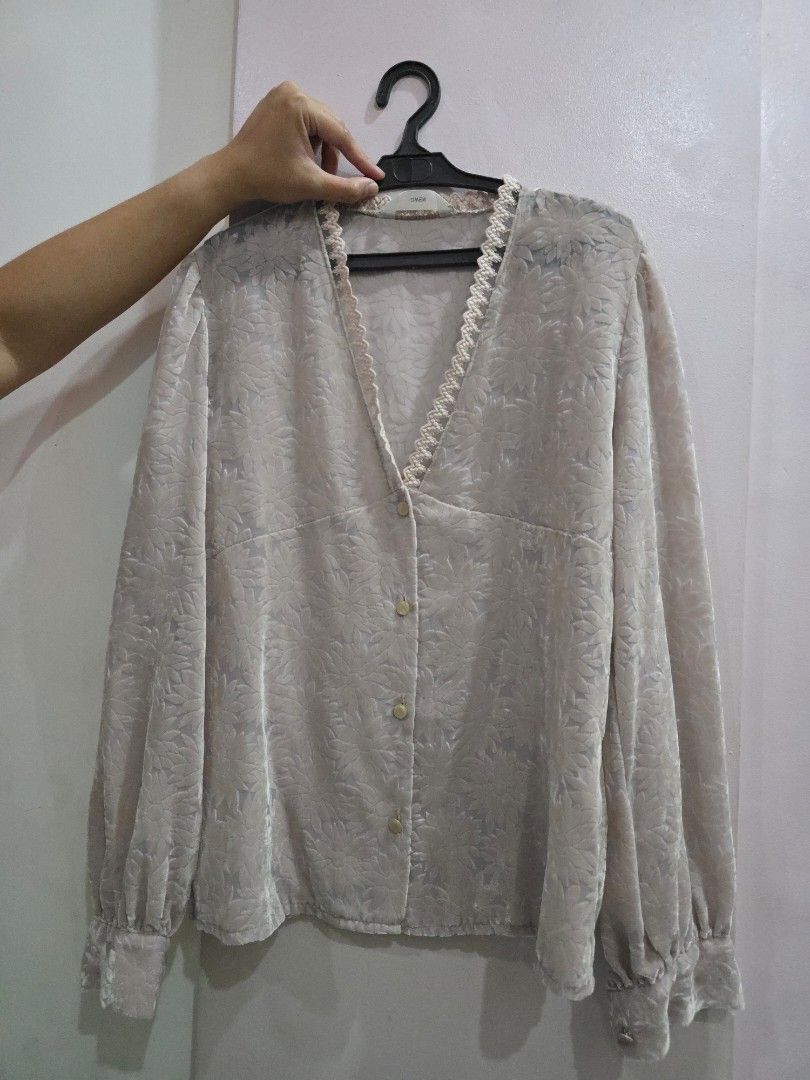 Lace Floral Korean Blouse (Category: Blouses) located in Valenzuela. Submitted by cbianx (Listing ID 1433109434, Image 1). Description: - Korean-made blouse - Delicate floral pattern - V-neckline with lace trim - Long sleeves - Button-down front - Soft, textured fabric - Light, neutral color.
