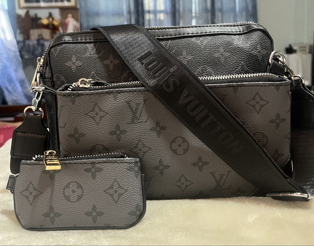 Louis Vuitton Trio Messenger Monogram Eclipse (Category: Ear Care) located in Mandaue City. Submitted by chuchi152615 (Listing ID 1433179781, Image 1). Description: - Louis Vuitton Messenger Bag - Monogram Eclipse Pattern - Includes: Main bag, small pouch, and coin purse - Adjustable black strap with "LOUIS VUITTON" print - Silver zippers with Louis Vuitton logo - Grey fabric interior lining - Features Louis Vuitton label.
