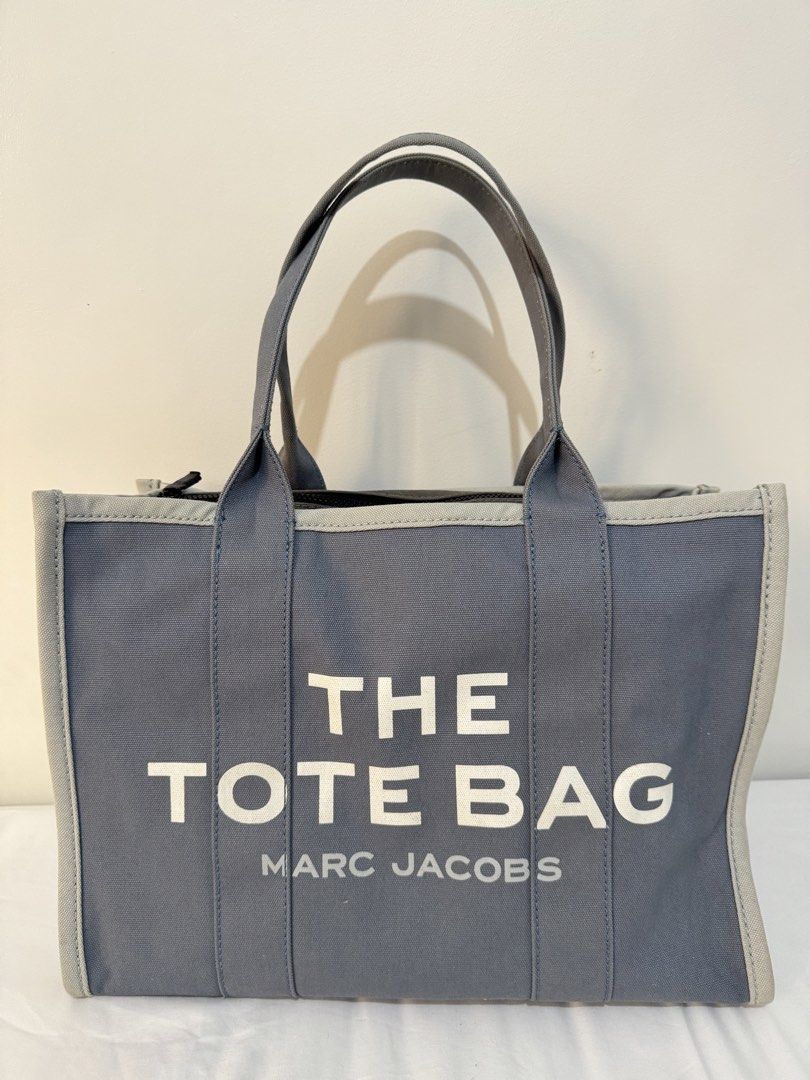 Marc Jacobs The Tote Bag - Large (Category: Luxury Bags & Wallets) located in Pasig City. Submitted by joyshares (Listing ID 1433102570, Image 1). Description: - Authentic Marc Jacobs The Tote Bag - Large size - Stylish blue canvas exterior - Features the iconic Marc Jacobs branding - Secure zippered main compartment - Includes an interior pocket for organization .