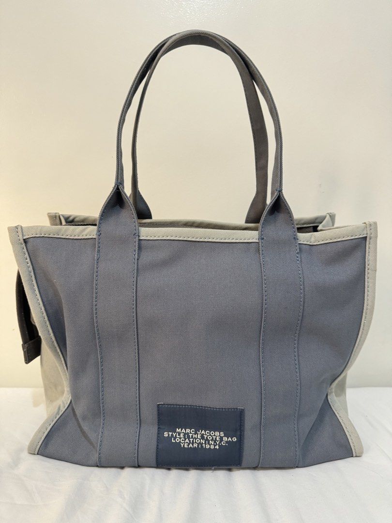 Marc Jacobs The Tote Bag - Large (Category: Luxury Bags & Wallets) located in Pasig City. Submitted by joyshares (Listing ID 1433102570, Image 2). Description: - Authentic Marc Jacobs The Tote Bag - Large size - Stylish blue canvas exterior - Features the iconic Marc Jacobs branding - Secure zippered main compartment - Includes an interior pocket for organization .