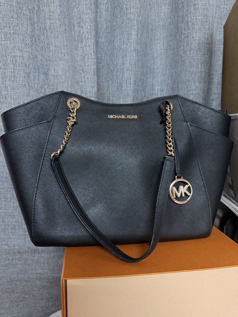 Michael Kors Black Tote Bag (Category: Luxury Bags & Wallets) located in Manila. Submitted by cmmango (Listing ID 1433078944, Image 1). Description: - Black Michael Kors tote bag - Gold-tone chain straps - MK logo charm - Two side pockets - Spacious interior - Structured shape with subtle sheen - Michael Kors logo visible - Ideal for everyday use.