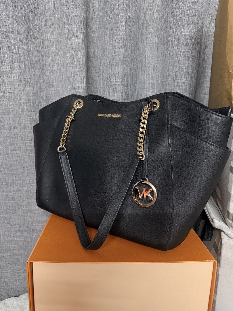 Michael Kors Black Tote Bag (Category: Luxury Bags & Wallets) located in Manila. Submitted by cmmango (Listing ID 1433078944, Image 2). Description: - Black Michael Kors tote bag - Gold-tone chain straps - MK logo charm - Two side pockets - Spacious interior - Structured shape with subtle sheen - Michael Kors logo visible - Ideal for everyday use.