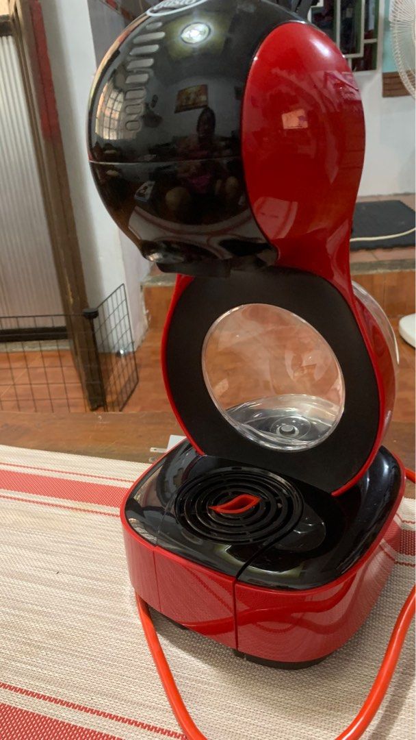Nescafe Dolce Gusto Coffee Machine (Category: Coffee Machines & Makers) located in Pasig City. Submitted by shopsukiph (Listing ID 1433019928, Image 3). Description: - Red and black Nescafe Dolce Gusto coffee machine - Features a water reservoir - Includes a capsule holder - Comes with a power cord and plug - Designed to make various coffee drinks - Machine is in good working order.