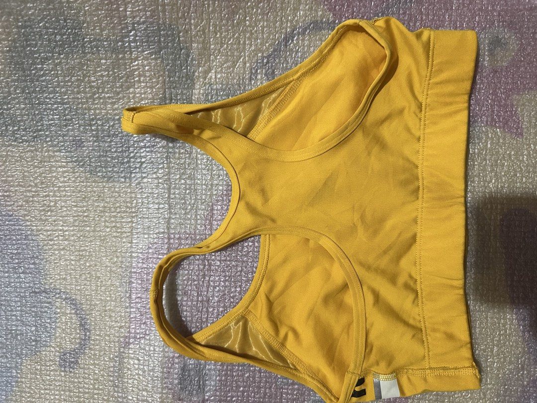 Pink Victoria's Secret Ultimate Sports Bra (Category: Activewear) located in Manila. Submitted by juanabanana (Listing ID 1433140958, Image 3). Description: Yellow sports bra from Pink Victoria's Secret. Features the brand name across the chest in black lettering with a white and silver stripe. The bra has a racerback design. Size is S/P (Small/Petite). The bra is made of a blend of polyester and spandex. Needs wash.