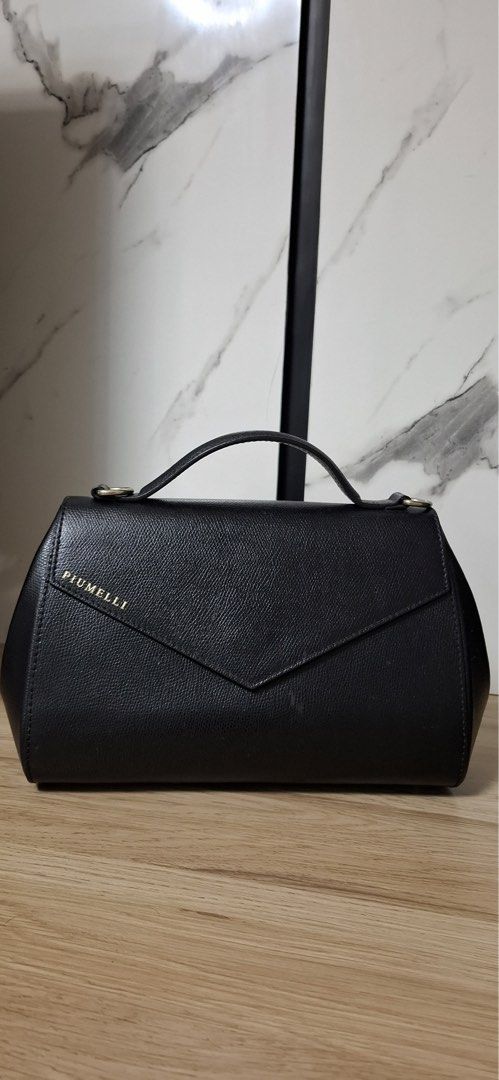 Piumelli Black Handbag with Pearl Strap (Category: Luxury Bags & Wallets) located in Cauayan City . Submitted by best_buyph_88 (Listing ID 1433152364, Image 1). Description: - Piumelli black handbag - Top handle - Unique flap closure - Detachable strap with pearls and studs - Made of leather - Perfect for any occasion -with extra Piumelli strap worth 4k .