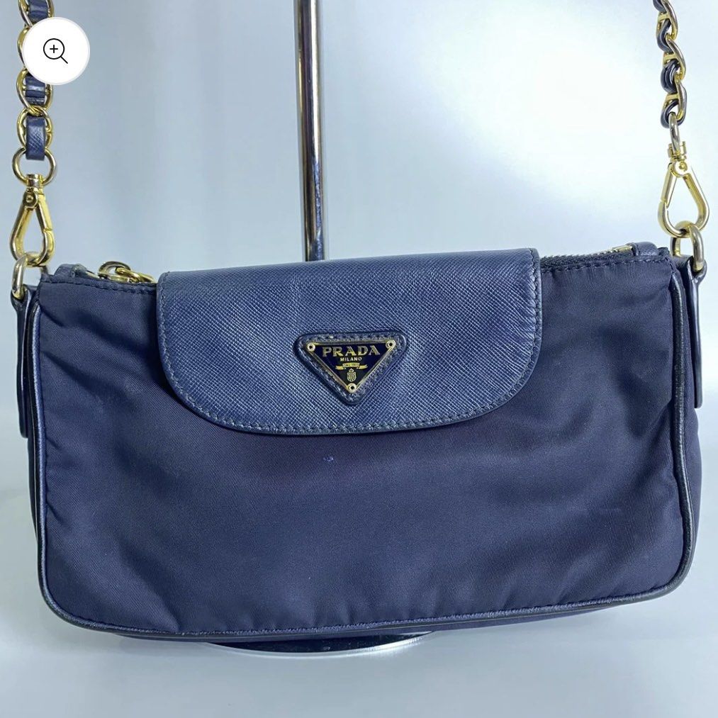 Prada Nylon Chain Crossbody Bag (Category: Luxury Bags & Wallets) located in Pasig City. Submitted by _mikha (Listing ID 1433071415, Image 1). Description: - Authentic Prada crossbody bag - Navy blue color - Flap closure with Prada logo - Gold-tone chain strap - Prada-branded interior lining - Includes dust bag - Zipper closure - Small leather detail - Issue: Notable fading on the chain.