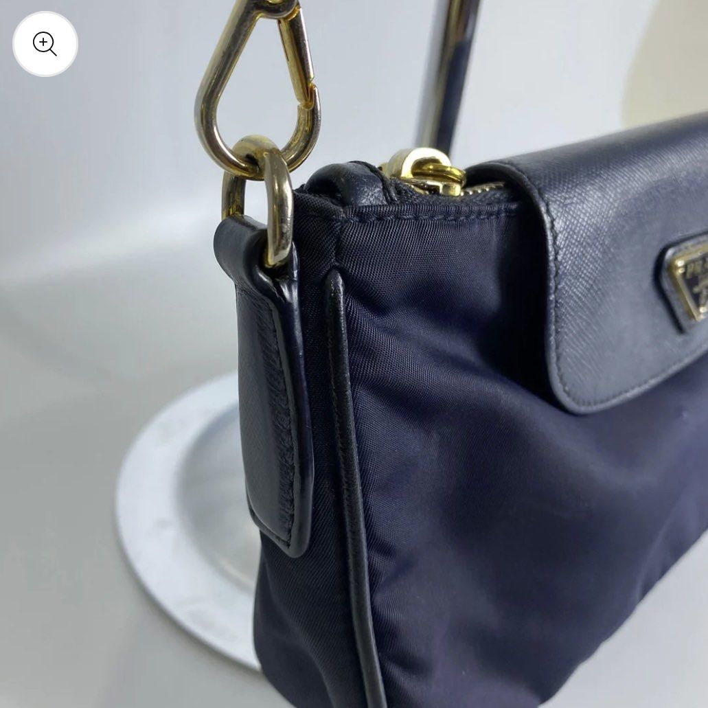 Prada Nylon Chain Crossbody Bag (Category: Luxury Bags & Wallets) located in Pasig City. Submitted by _mikha (Listing ID 1433071415, Image 2). Description: - Authentic Prada crossbody bag - Navy blue color - Flap closure with Prada logo - Gold-tone chain strap - Prada-branded interior lining - Includes dust bag - Zipper closure - Small leather detail - Issue: Notable fading on the chain.