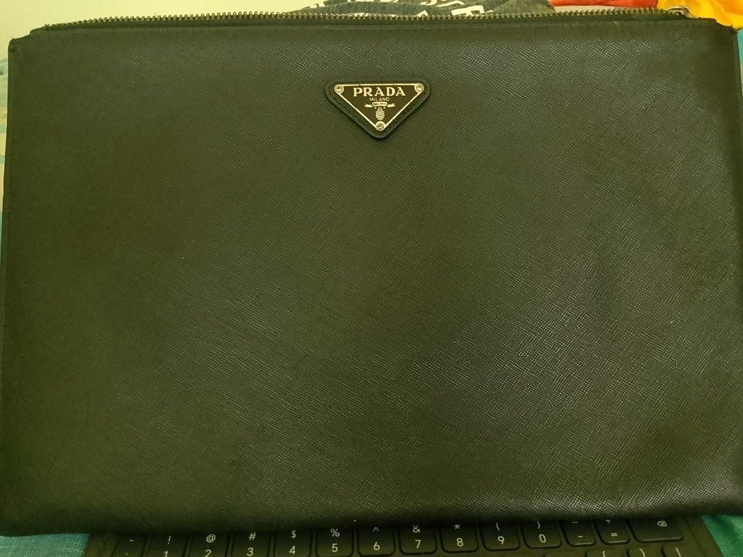Prada Saffiano Document Clutch (2VN003) (Category: Luxury Bags & Wallets) located in Quezon City. Submitted by annyeong9 (Listing ID 1433180649, Image 1). Description: Prada Saffiano document clutch/ tablet pouch -fit for a tablet size 10.5 in x 7 in. - Color: Black - Features: - Zip closure - Prada triangle logo - Multiple interior compartments - Material: Saffiano leather - Model number: L343569 - Original price: ₱39,197.46.