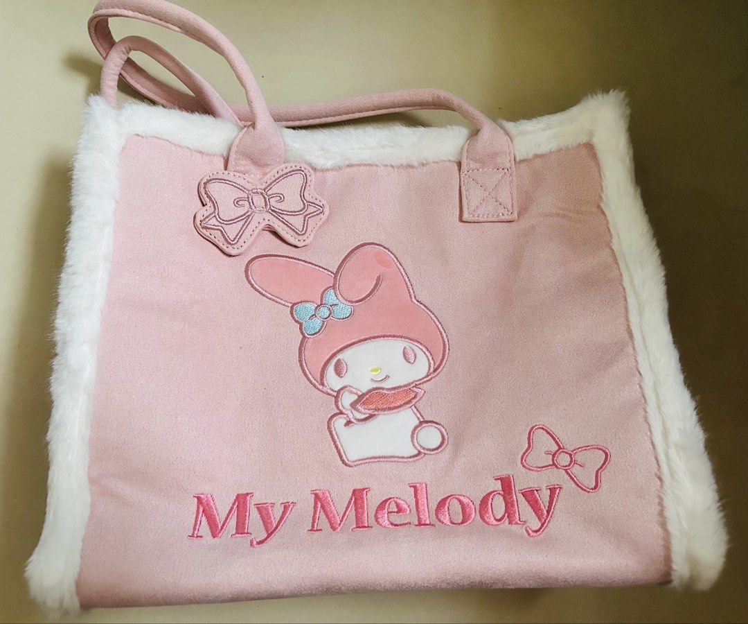 Sanrio My Melody Tote Bag (Category: Tote Bags) located in Pasig City. Submitted by jrrhs (Listing ID 1433099112, Image 1). Description: - Adorable My Melody tote bag - Pink exterior with My Melody embroidery and bow - Pink interior with pockets - White fluffy trim and handles - Includes Sanrio tag - Made in China.