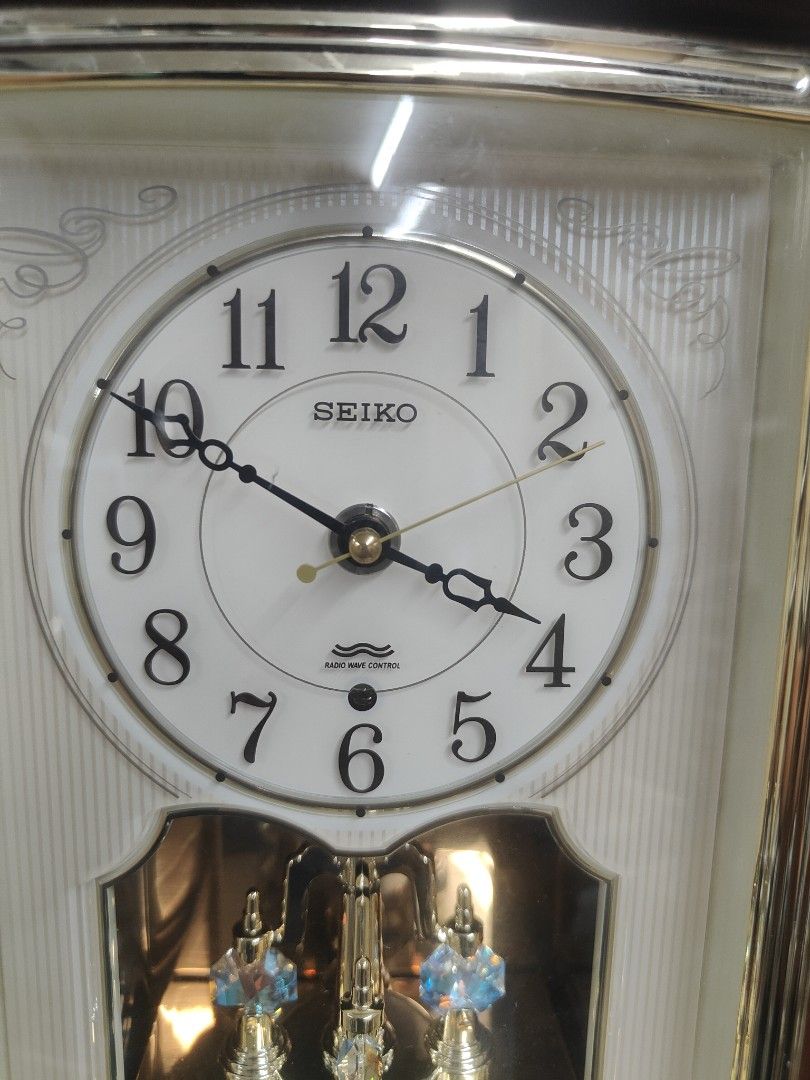 Seiko Anniversary Clock (Category: Clocks) located in Cavite. Submitted by sevillajoh71978 (Listing ID 1433081589, Image 1). Description: - Seiko anniversary clock - White face with black numerals - Wooden frame - Decorative pendulum with blue crystal accents - Features Japanese text (possibly a special edition) - Requires AA batteries.