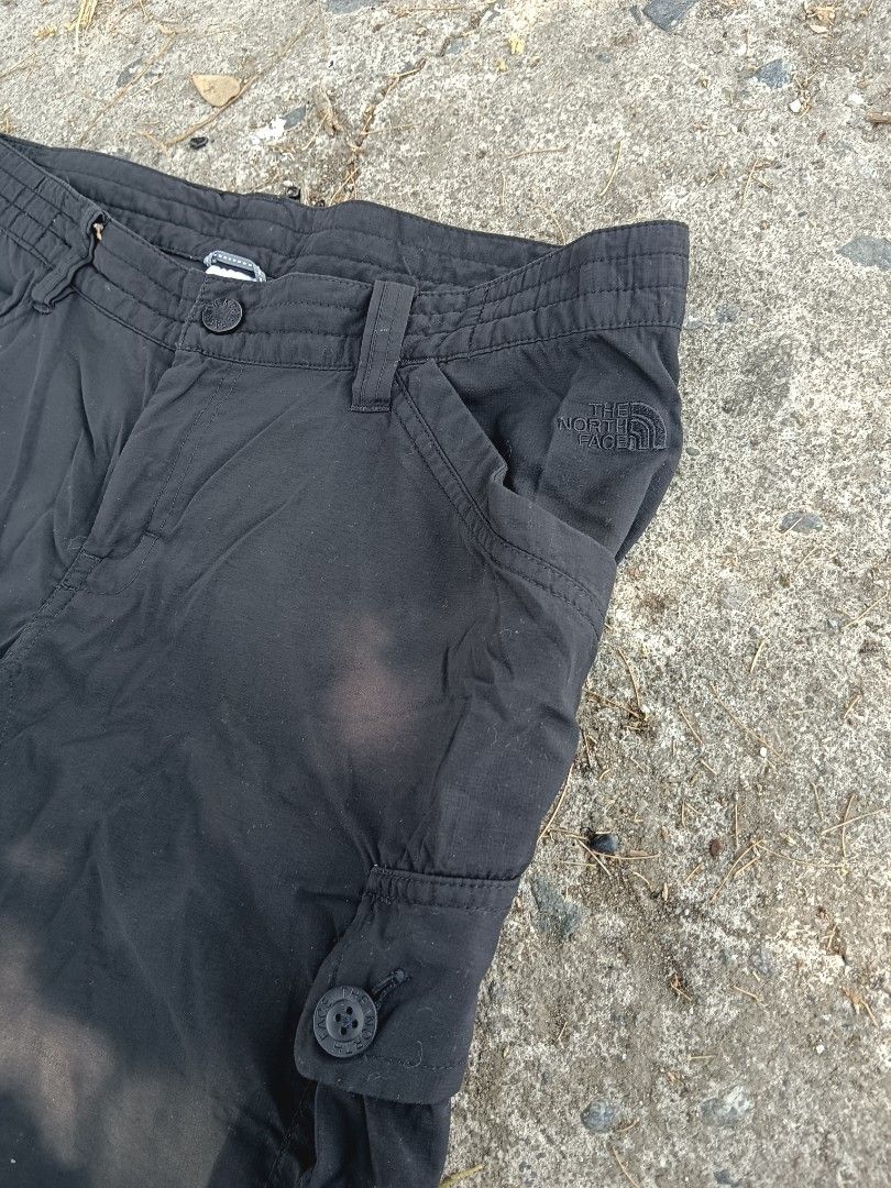 The North Face Convertible Cargo Pants (Category: Joggers) located in Tarlac. Submitted by khrizson16 (Listing ID 1433034662, Image 2). Description: - The North Face convertible cargo pants - Black color - Converts into shorts - Features multiple pockets: cargo pockets on the sides and a zipper pocket at the back - North Face logo on front and back - Size tag is visible.