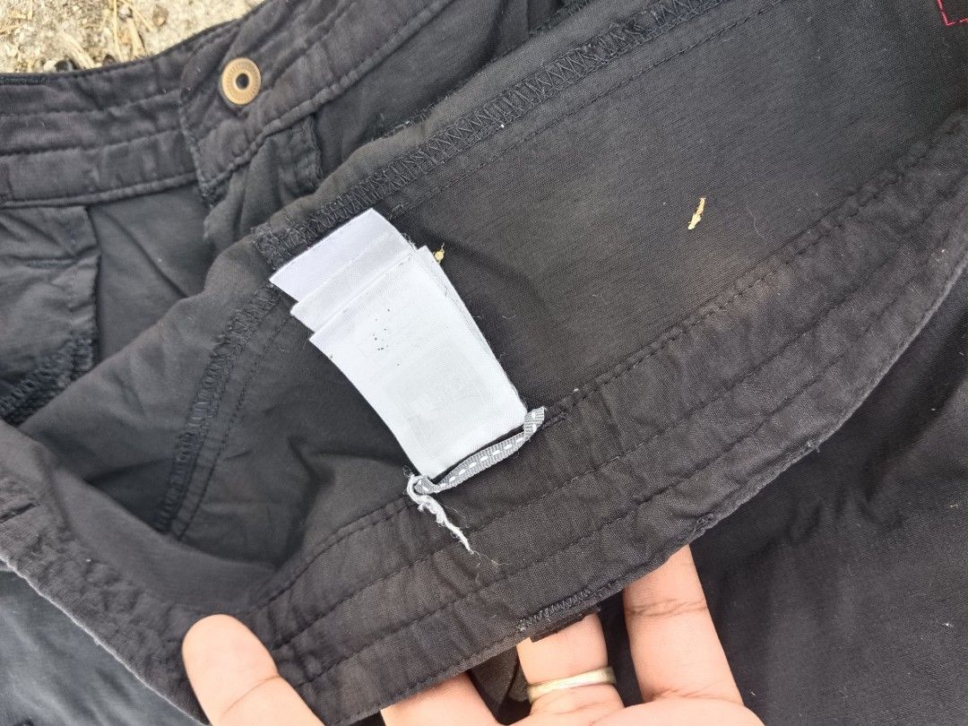 The North Face Convertible Cargo Pants (Category: Joggers) located in Tarlac. Submitted by khrizson16 (Listing ID 1433034662, Image 3). Description: - The North Face convertible cargo pants - Black color - Converts into shorts - Features multiple pockets: cargo pockets on the sides and a zipper pocket at the back - North Face logo on front and back - Size tag is visible.