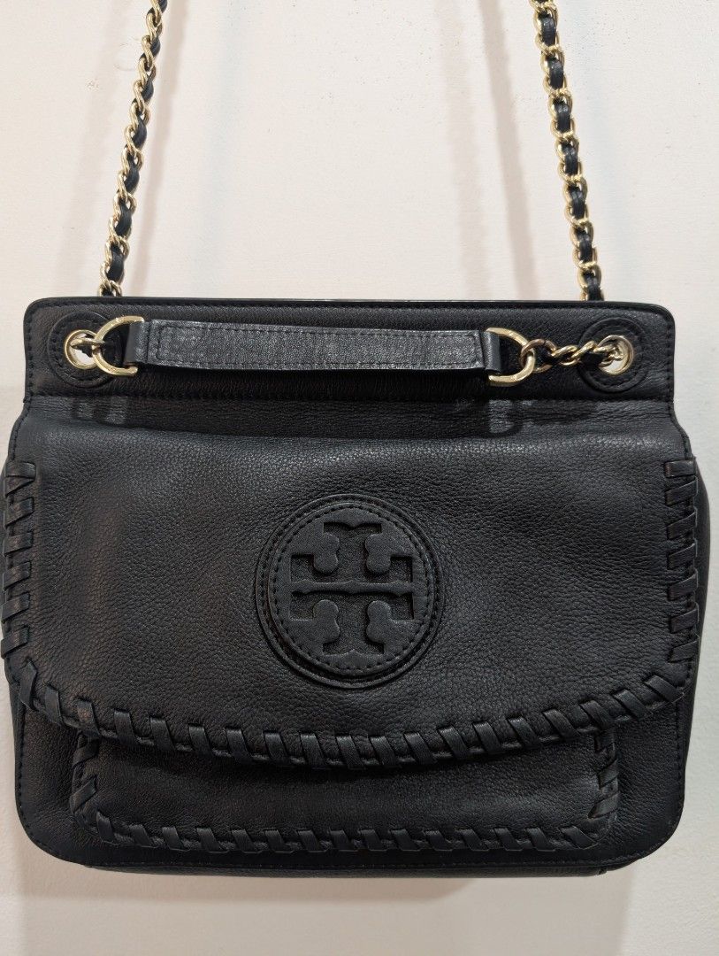 Tory Burch Black Leather Shoulder Bag (Category: Luxury Bags & Wallets) located in San Pedro. Submitted by 264nine (Listing ID 1433098078, Image 2). Description: - Elegant gold chain strap; 2 way strap - Secure flap closure with the iconic Tory Burch logo. - Stylish stitched design. - Convenient small front pocket. - Luxurious interior with a gold logo emblem. - Bag only.