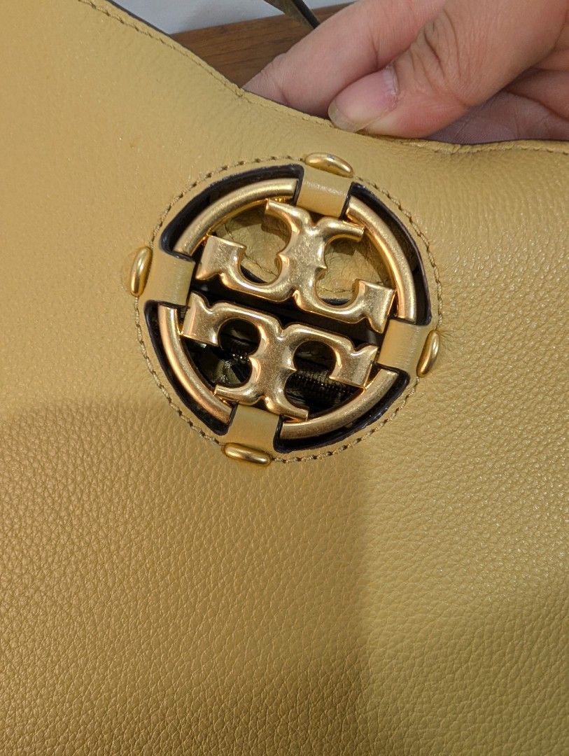 Tory Burch Shoulder Bag (Category: Luxury Bags & Wallets) located in San Pedro. Submitted by 264nine (Listing ID 1433095939, Image 2). Description: - Yellow shoulder bag - Gold-tone logo - Rounded shape with contrasting trim - Adjustable shoulder strap - Textured leather exterior.