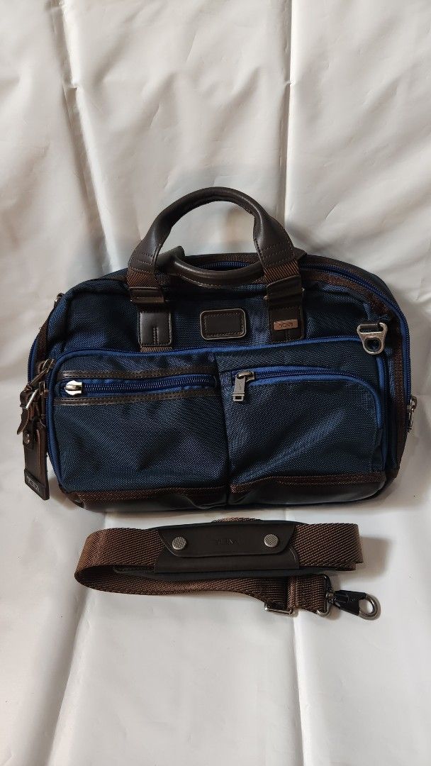 Tumi Alpha Bravo Briefcase (Category: Briefcases) located in Antipolo. Submitted by luislasi (Listing ID 1433145509, Image 1). Description: - Tumi Alpha Bravo Andersen briefcase - Navy blue exterior with brown leather accents - Detachable shoulder strap included - Multiple zippered compartments for secure storage - Interior features patterned lining - Top handle for easy carrying - Small hole on right buckle. Needs re-stiching but still usable.