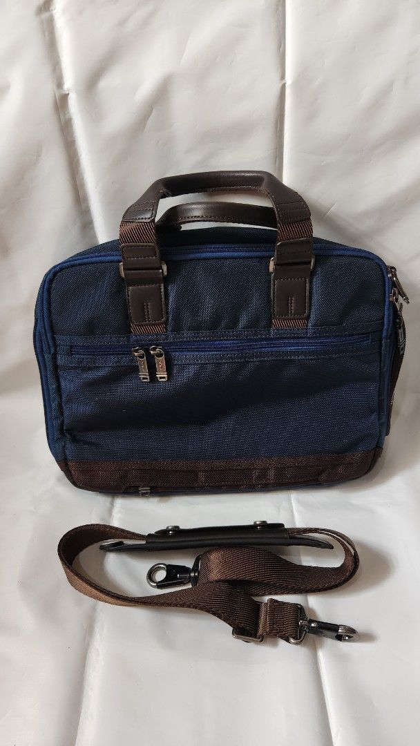 Tumi Alpha Bravo Briefcase (Category: Briefcases) located in Antipolo. Submitted by luislasi (Listing ID 1433145509, Image 2). Description: - Tumi Alpha Bravo Andersen briefcase - Navy blue exterior with brown leather accents - Detachable shoulder strap included - Multiple zippered compartments for secure storage - Interior features patterned lining - Top handle for easy carrying - Small hole on right buckle. Needs re-stiching but still usable.
