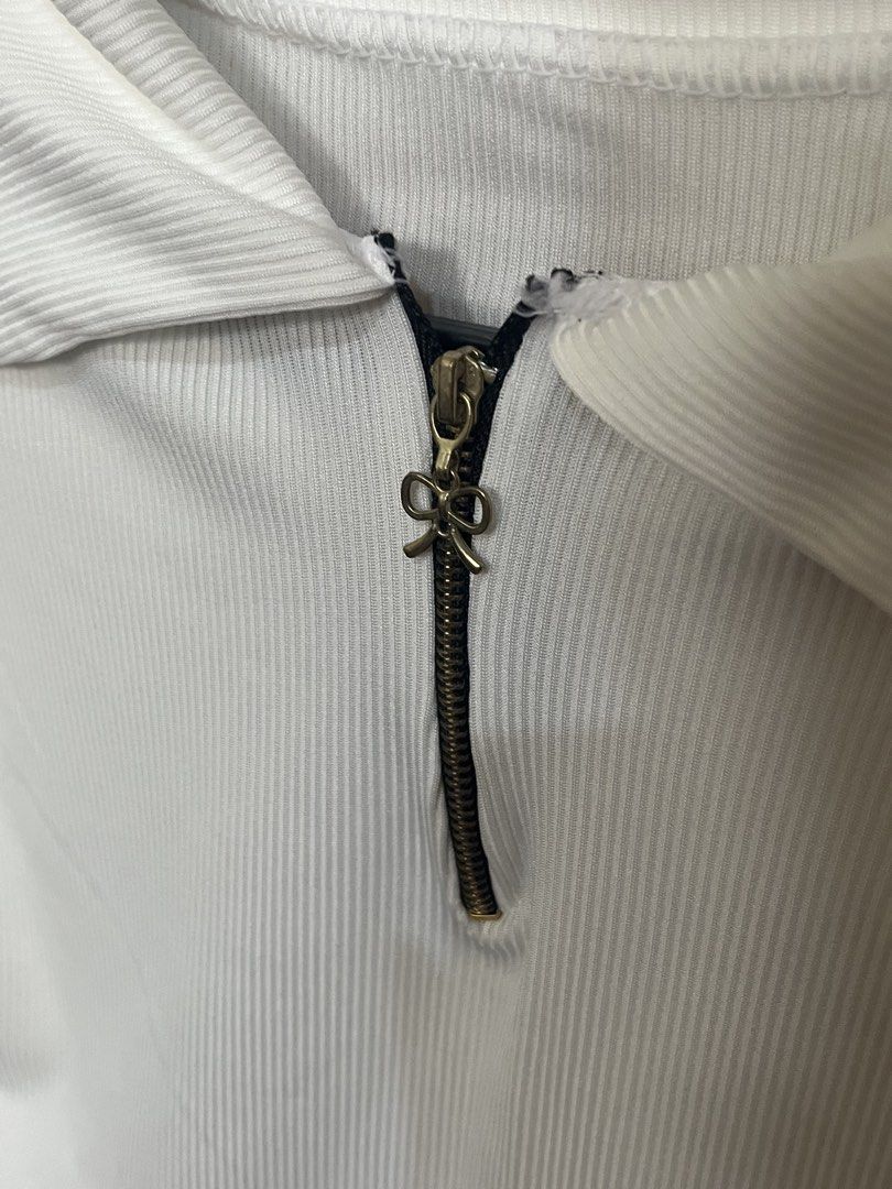 White Long Sleeve Crop Top with Zipper (Category: Longsleeves) located in San Juan City. Submitted by louiseclothes (Listing ID 1433028474, Image 2). Description: - White long-sleeved crop top - Collared neckline - Zipper closure with decorative bow charm - Ribbed texture - Fitted style.