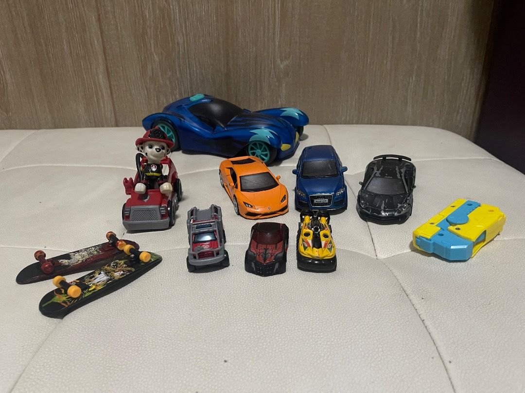Assorted Toy Cars and Skateboards (Category: Vehicle & Diecast Models) located in Marikina City. Submitted by bezz_bezzy (Listing ID 1429770080, Image 1). Description: Collection of toy cars and skateboards. Includes a blue sports car, an orange Lamborghini-style car, a blue sedan, a black sports car, and several smaller toy cars. Also includes two skateboards. Perfect for kids who love cars and skateboarding..