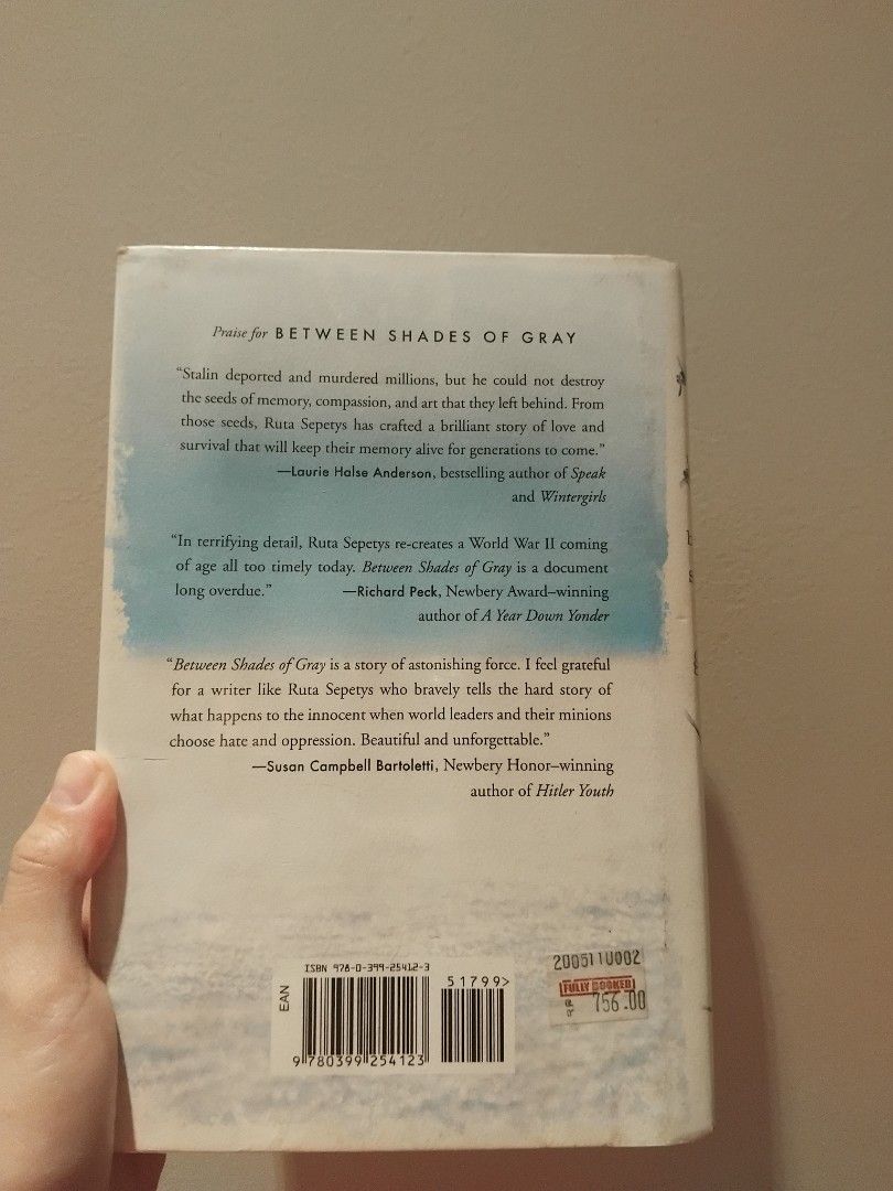 Between Shades of Gray (Category: Storybooks) located in Marikina City. Submitted by danicecedro (Listing ID 1429810531, Image 2). Description: Copy of the novel "Between Shades of Gray" by Ruta Sepetys. The book has a blue and white cover with the title and author's name visible. The back of the book includes a summary and quotes. The pages appear to be slightly yellowed with age. The book is in English..