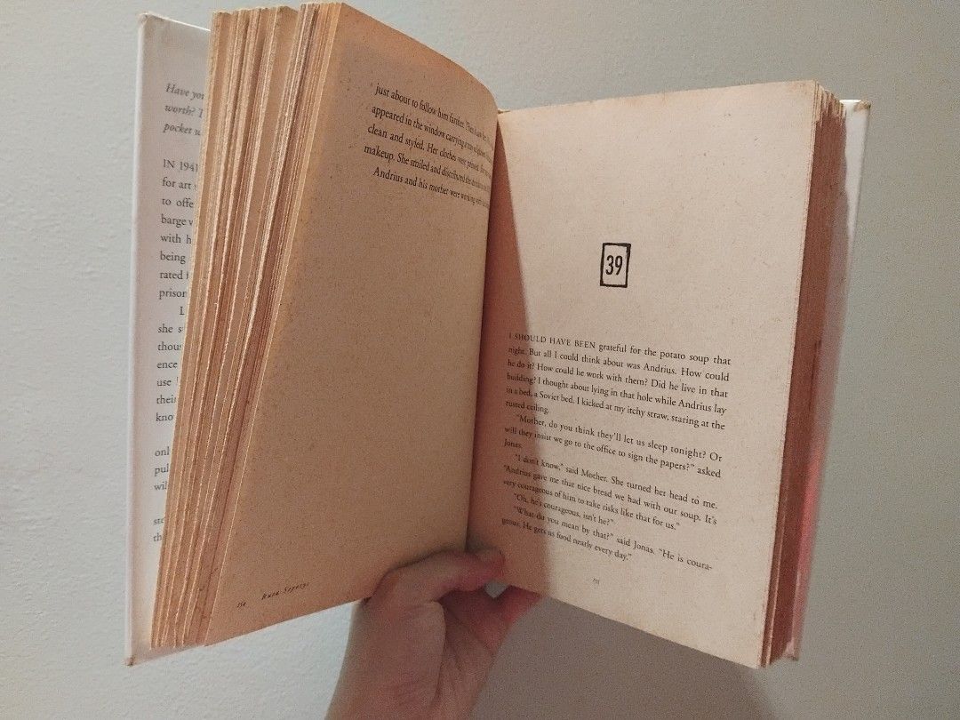 Between Shades of Gray (Category: Storybooks) located in Marikina City. Submitted by danicecedro (Listing ID 1429810531, Image 3). Description: Copy of the novel "Between Shades of Gray" by Ruta Sepetys. The book has a blue and white cover with the title and author's name visible. The back of the book includes a summary and quotes. The pages appear to be slightly yellowed with age. The book is in English..