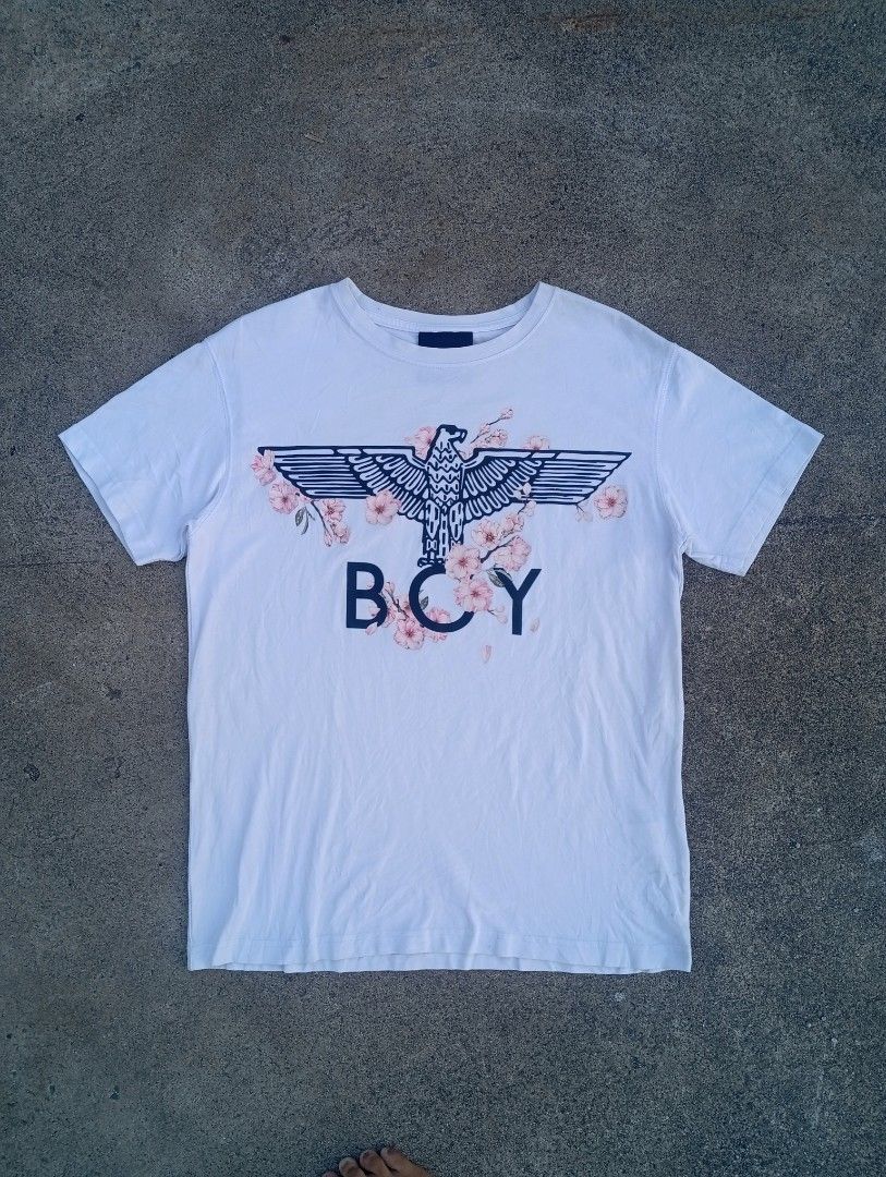 Boy London Eagle Print T-shirt (Category: Tshirts & Polo Shirts ) located in Taguig. Submitted by aron_robrigado (Listing ID 1429781211, Image 1). Description: White Boy London T-shirt featuring an eagle and floral print design. The shirt has a crew neck and short sleeves. The size is S. The tag shows the brand's website. The shirt is made of 100% cotton. The shirt has a tag with washing instructions..