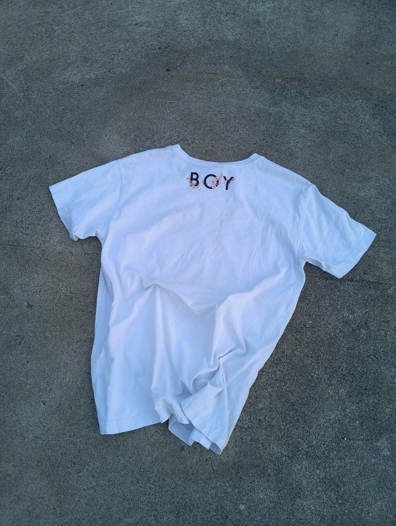 Boy London Eagle Print T-shirt (Category: Tshirts & Polo Shirts ) located in Taguig. Submitted by aron_robrigado (Listing ID 1429781211, Image 2). Description: White Boy London T-shirt featuring an eagle and floral print design. The shirt has a crew neck and short sleeves. The size is S. The tag shows the brand's website. The shirt is made of 100% cotton. The shirt has a tag with washing instructions..