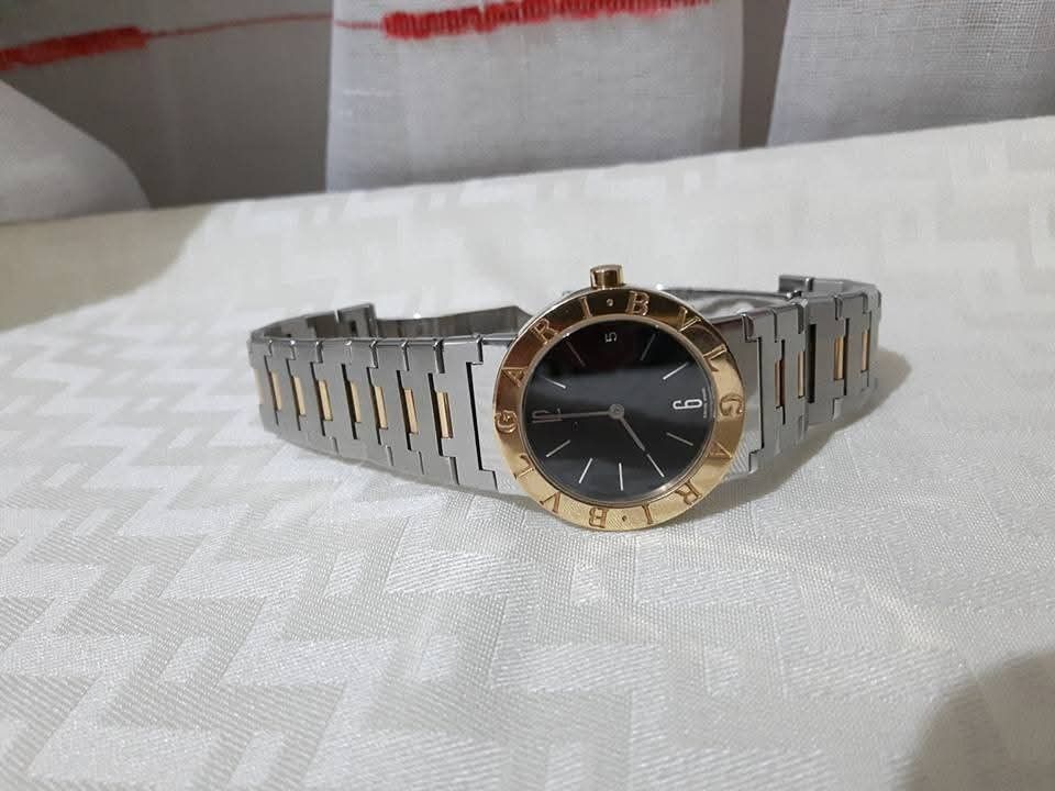 Bulgari Bulgari Watch (Category: Luxury Watches) located in Pasig City. Submitted by castlescollections (Listing ID 1429696451, Image 1). Description: Elegant Bulgari Bulgari watch with a black dial and gold-tone bezel. The watch features a two-tone stainless steel and gold bracelet. The clasp is engraved with the Bulgari logo. The watch has a date display at the 3 o'clock position..