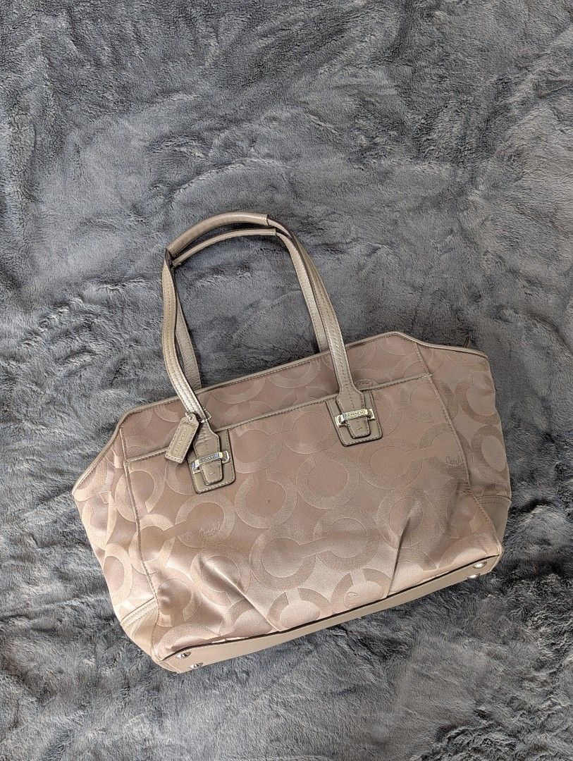 Coach Signature Tote Bag (Category: Luxury Bags & Wallets) located in Manila. Submitted by eladp (Listing ID 1429774337, Image 1). Description: 🌼original preloved items or you money back guaranteed. 🩷details: Coach tote bag in a neutral color. Features a signature pattern and multiple interior pockets. Includes a zipper closure and a Coach hang tag. The bag has double handles and a structured shape. Made in China. 🌼Clean and ready to use. With