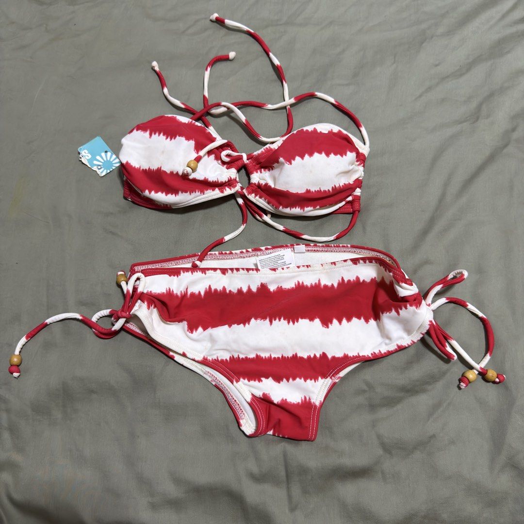 Coral Red and White Bikini Set - Size S (Category: Bikinis & Swimsuits) located in Paranaque City. Submitted by _mrs.j (Listing ID 1429773457, Image 1). Description: Bikini set features a red and white striped pattern. It includes a top with adjustable straps and wooden bead accents, along with matching bottoms. The size is small. The bikini is made of a stretchy material. The top has a tie-up design. The bottoms also have adjustable side ties..