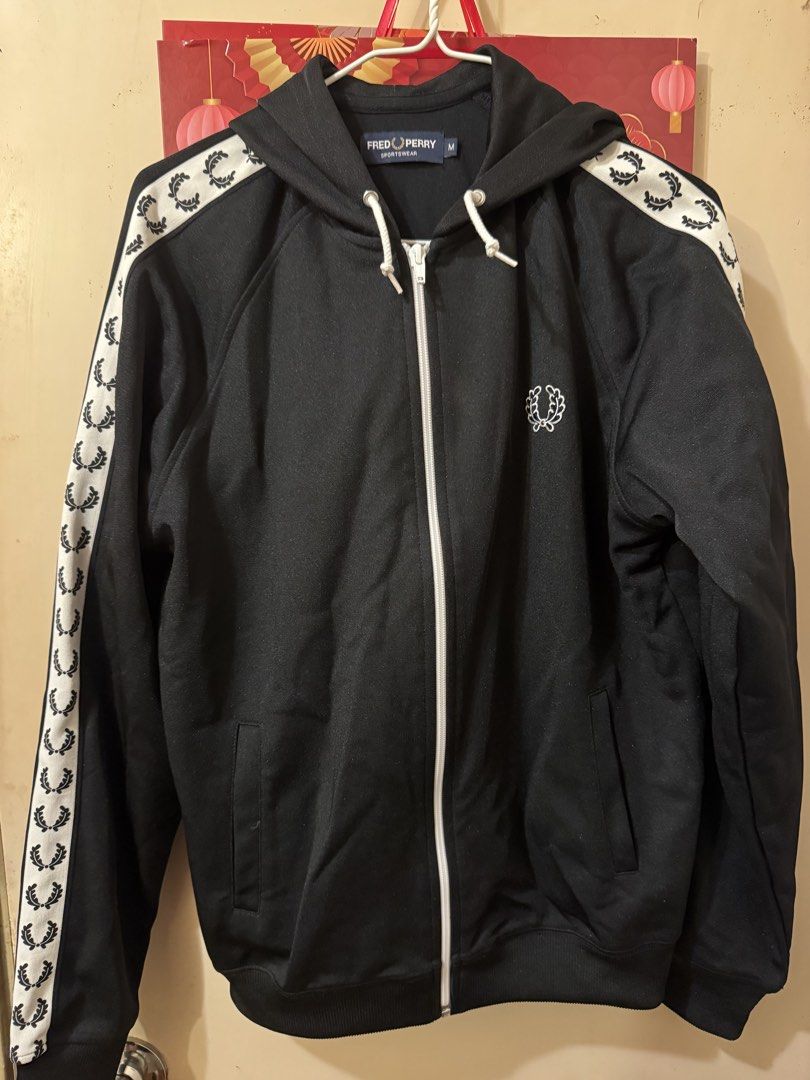 Fred Perry Black Track Jacket （分類：外套及戶外衣服）位於 Hong Kong。 由 rikimaru68 提交（商品編號 1417945649，圖片 1）。簡介： Black Fred Perry track jacket with white detailing on the sleeves. Features a full zip closure and a hood. The Fred Perry logo is embroidered on the chest. Made in Portugal.。