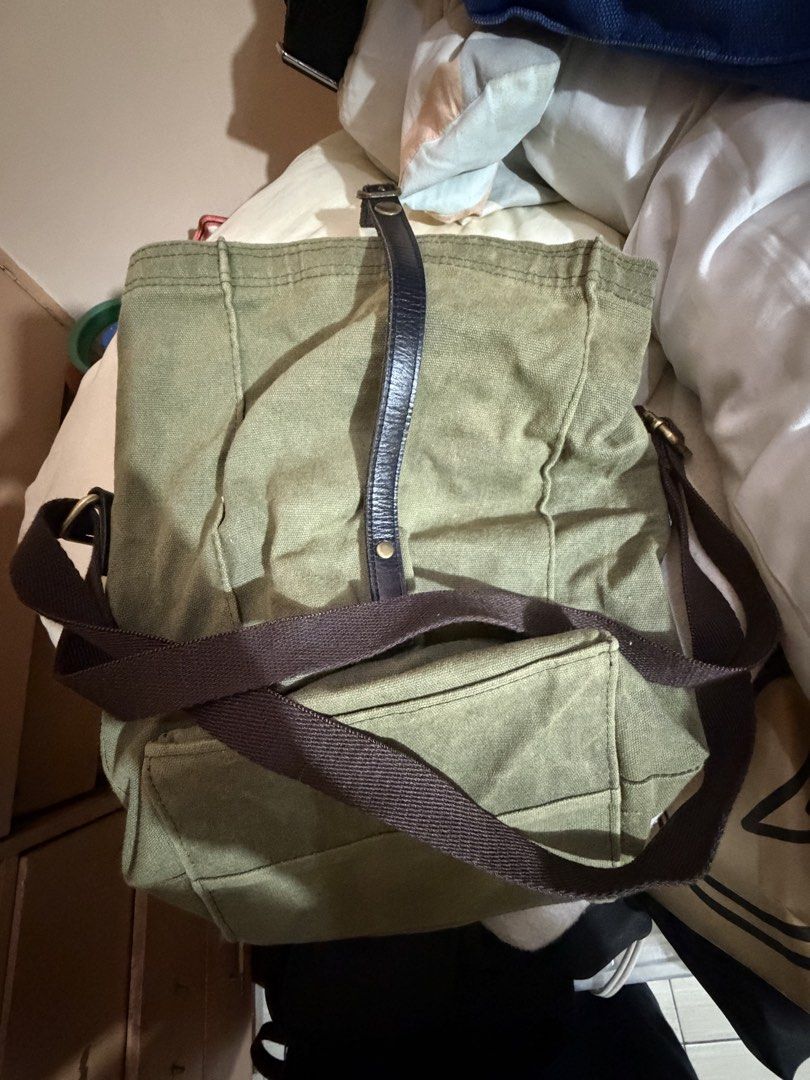 Gouache Canvas Shoulder Bag (lunch box) (Category: Shoulder Bags) located in Paranaque City. Submitted by prelovedlux83 (Listing ID 1429833564, Image 2). Description: Green canvas shoulder bag with a flap closure and adjustable strap. Features a leather accent on the flap and a small brand patch. The bag has a spacious interior. The bag has a brown strap and gold-colored hardware..