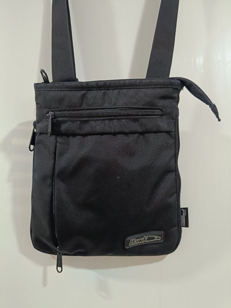 Hawk Crossbody Bag - Black (Category: Backpacks) located in Iloilo. Submitted by daddy_declutter (Listing ID 1429684317, Image 1). Description: Black Hawk crossbody bag. Features a main compartment with a zipper closure, a front zippered pocket, and an adjustable shoulder strap. Includes a small logo patch on the front. Suitable for everyday use..