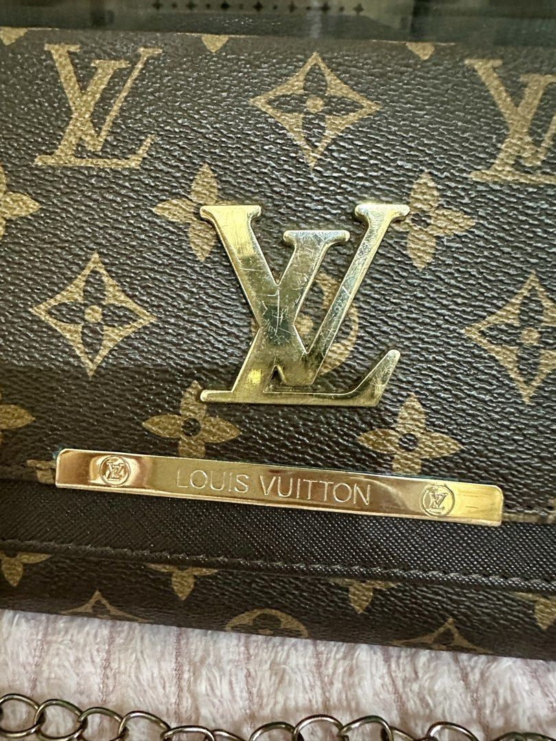 Louis Vuitton Monogram Chain Wallet (Category: Luxury Bags & Wallets) located in Talavera. Submitted by elledepartment (Listing ID 1429722652, Image 2). Description: Louis Vuitton Monogram chain wallet with a gold-tone logo and chain strap. The wallet features the classic LV monogram pattern. It has a flap closure and a silver chain strap. Issue: Signs of usage in the logo.