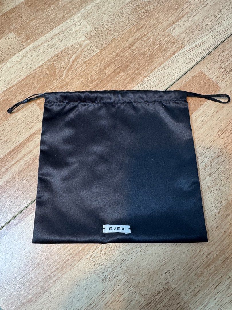 Miu Miu Black Dust Bag (Category: Luxury Bags & Wallets) located in Baguio. Submitted by goodfindsbaguio (Listing ID 1429813728, Image 1). Description: Authentic Miu Miu dust bag. Made of black satin-like material. Features a drawstring closure. The bag has a small Miu Miu label at the bottom. The material is 100% polyester. Measurements are approximately 25cm x 20cm..