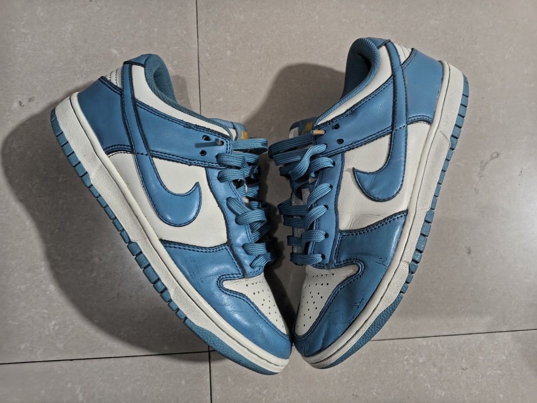 Nike Dunk Low UNC (Category: Sneakers) located in Las Pinas. Submitted by ejalaisa0018665 (Listing ID 1429779118, Image 1). Description: Nike Dunk Low in a University Blue and White colorway. Features a leather upper with a white base and blue overlays. The iconic Nike swoosh is visible on the sides. The shoe has a padded collar and tongue for comfort. The outsole is blue and the laces are blue..