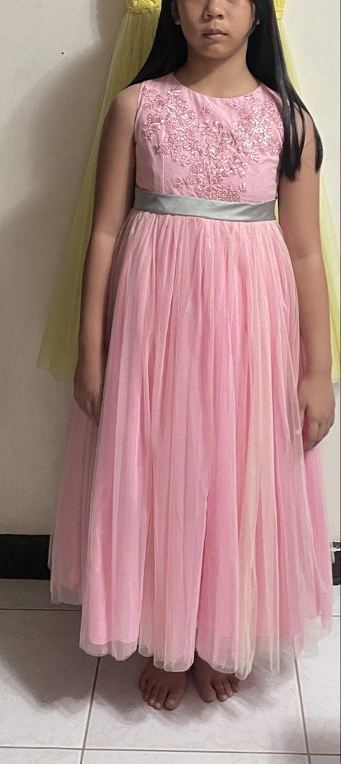 Pink Formal Gown (Category: Babies & Kids Fashion) located in Quezon City. Submitted by kheekai (Listing ID 1429792635, Image 2). Description: Elegant pink formal gown. Features a detailed embroidered bodice and a flowing tulle skirt. Includes a silver-grey ribbon at the waist. Perfect for special occasions. Sleeveless design. Fit 7-10, depends on body built.