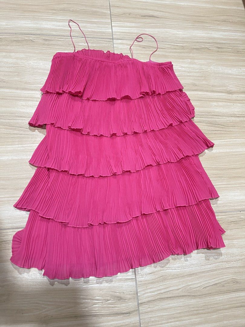 Pink Tiered Mini Dress (Category: Dresses) located in Manila. Submitted by cailleshope (Listing ID 1429719026, Image 2). Description: Vibrant pink mini dress features a tiered design with delicate spaghetti straps. The dress is made of pleated fabric, offering a flowy and flattering silhouette. It is a size M Perfect for a casual day out or a special occasion..
