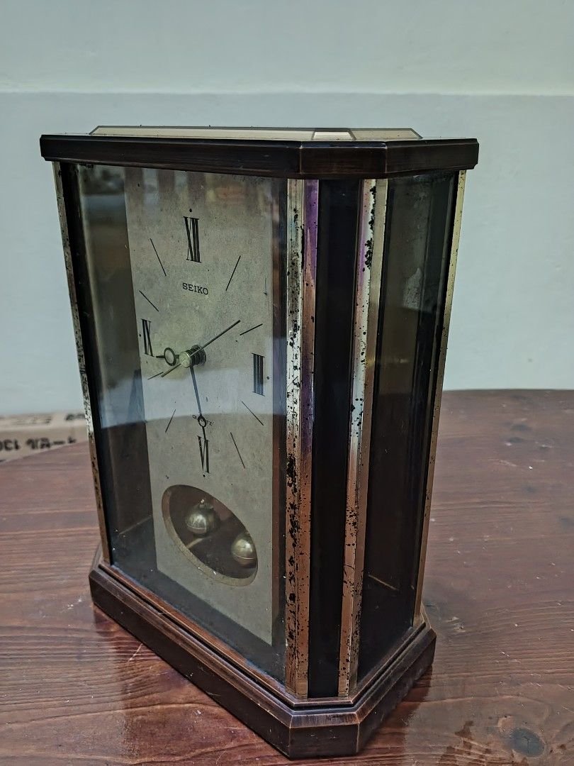 Seiko Pendulum Clock (Category: Clocks) located in Caloocan City. Submitted by surplusandbnewshop (Listing ID 1429793927, Image 3). Description: Vintage Seiko pendulum clock. Features a rectangular glass case with a wooden frame. The clock face has Roman numerals and the Seiko logo. The pendulum is visible through the glass. The back of the clock shows the clock mechanism. Requires batteries..