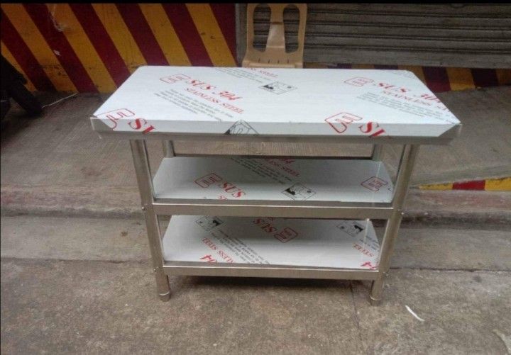 Stainless Steel Kitchen Table with Shelf (Category: Tables & Sets) located in Manila. Submitted by davearonda40644 (Listing ID 1429790426, Image 2). Description: Durable stainless steel kitchen table with a convenient shelf for extra storage. Features a sleek, modern design. Constructed with SUS 304 stainless steel. Ideal for food preparation or as a work surface. The table has a sturdy build and is easy to clean. Perfect for commercial or home u