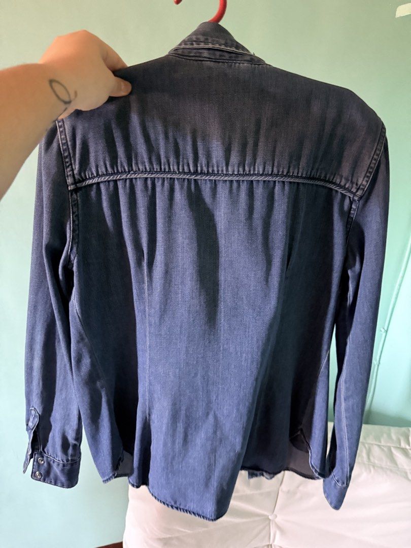 Zara Denim Shirt/ Jacket (Category: Coats, Jackets and Outerwear) located in Cainta. Submitted by Kamilerloo (Listing ID 1429700351, Image 1). Description: Denim jacket or shirt features a classic design with two chest pockets and buttoned cuffs. It has a collared neckline and a button-down front. It has a standard fit and long sleeves. The back of the shirt has a yoke detail. RFS: declutterring .